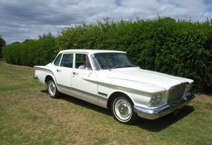 1962 Chrysler Valiant S Series sedan in white, front three-quarter view on grass