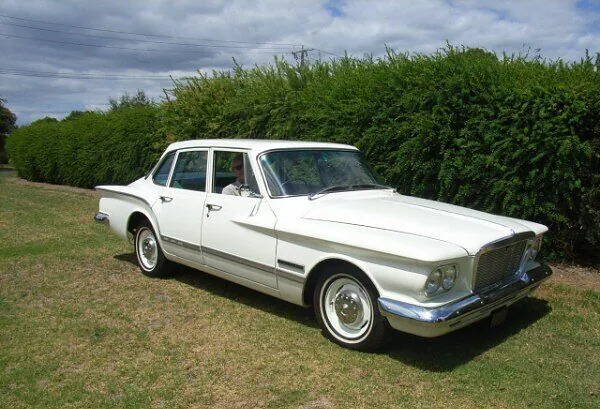 1962 Chrysler Valiant S Series sedan in white, front three-quarter view on grass