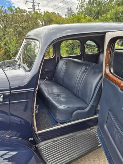 Black leather rear bench seat and timber window surrounds inside the 1936 Oldsmobile F-37 sedan