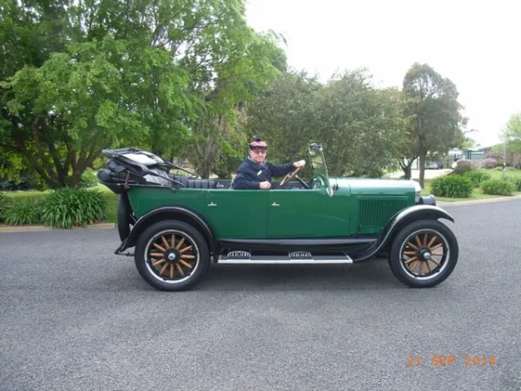 c1925 Oldsmobile Model 30 Tourer in green with the hood folded down, full side view on the road