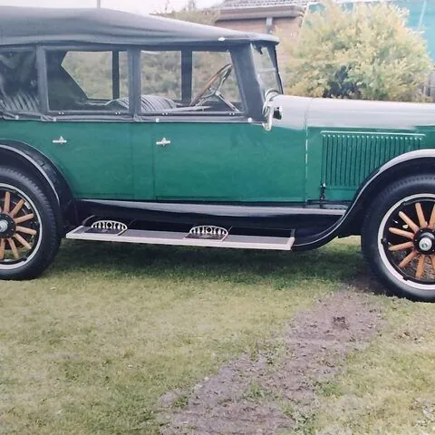 c1925 Oldsmobile Model 30 Tourer in green with black guards and timber-spoke wheels, full side view with the hood raised