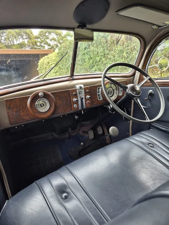 Front bench seat, steering wheel and woodgrain dashboard of the 1936 Oldsmobile F-37 sedan