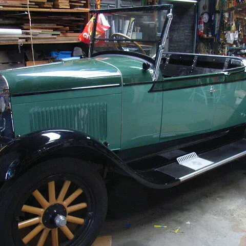 Restored c1928 Chevrolet Roadster in green with black guards and timber-spoke wheels, hood down, side three-quarter view