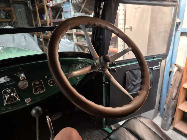 Timber-rimmed steering wheel, green dashboard and driver’s door of the c1925 Oldsmobile Model 30 Tourer